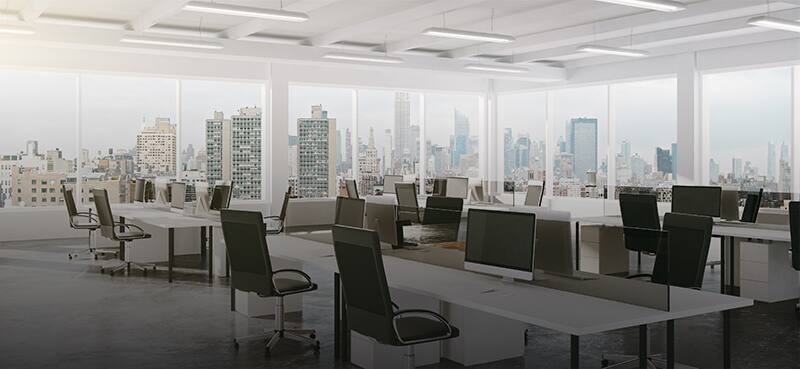 Empty modern office with lined up desks equipped with computers