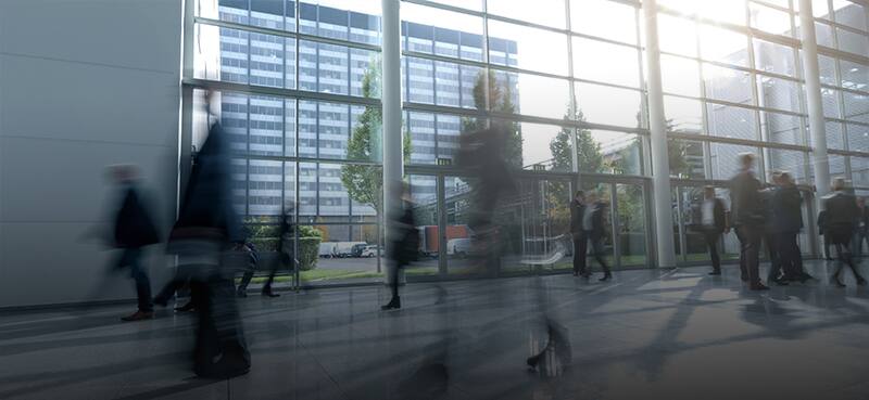Motion blur image of people walking in a busy office lobby