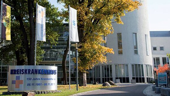 Exterior of a hospital building with a signboard