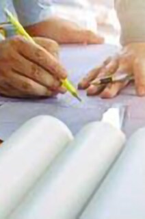 Close-up shot of a group of people having a discussion over a blueprint