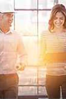 Engineer and female employee having a hearty conversation in office lobby