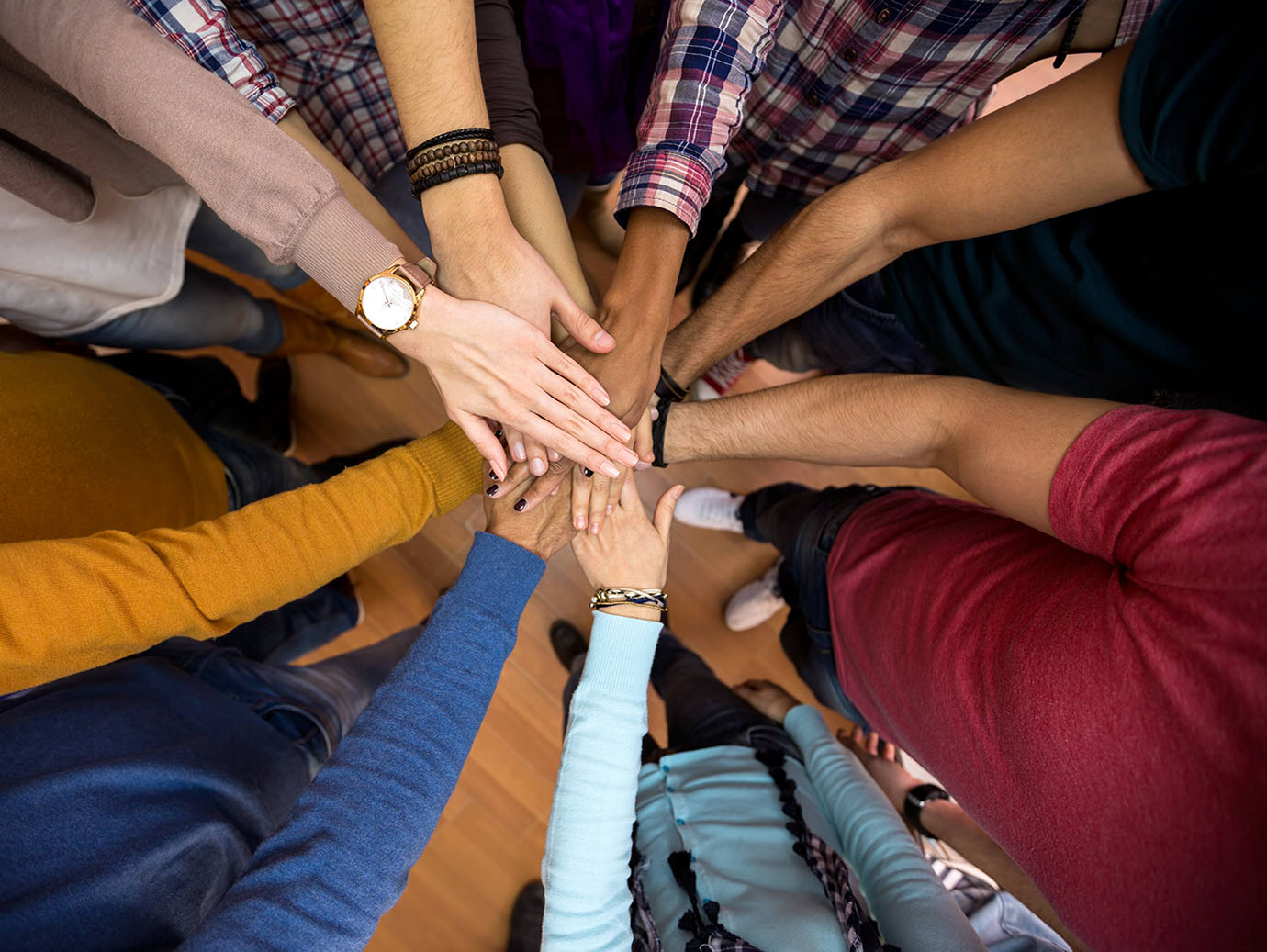 Downward shot of a team huddled up with their hands in the middle