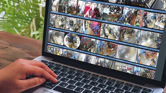 A man monitoring cctv footage on his laptop