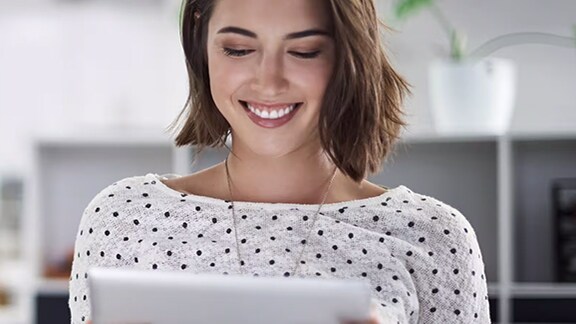 A lady happily looking at the tab