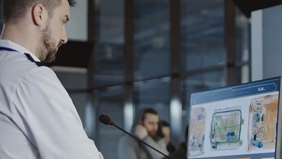 A person monitoring the security while watching the visuals at the entrance of a building