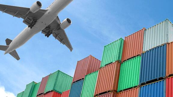 An airplane flying over cargo containers