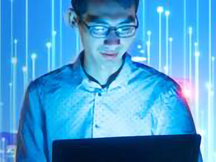 A blue image of a person looking at the laptop overlaid with graphics of transmission nodes