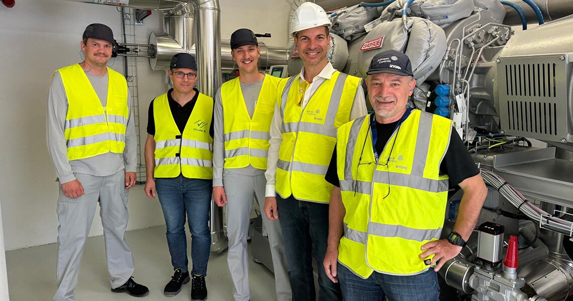 Johnson Controls technicians posing for a picture with a heat pump