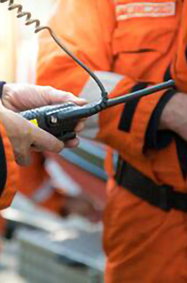 Close-up shot of a group of engineers in safety suits conversing with each other