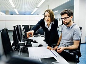 A man and a woman are discussing something inside an office