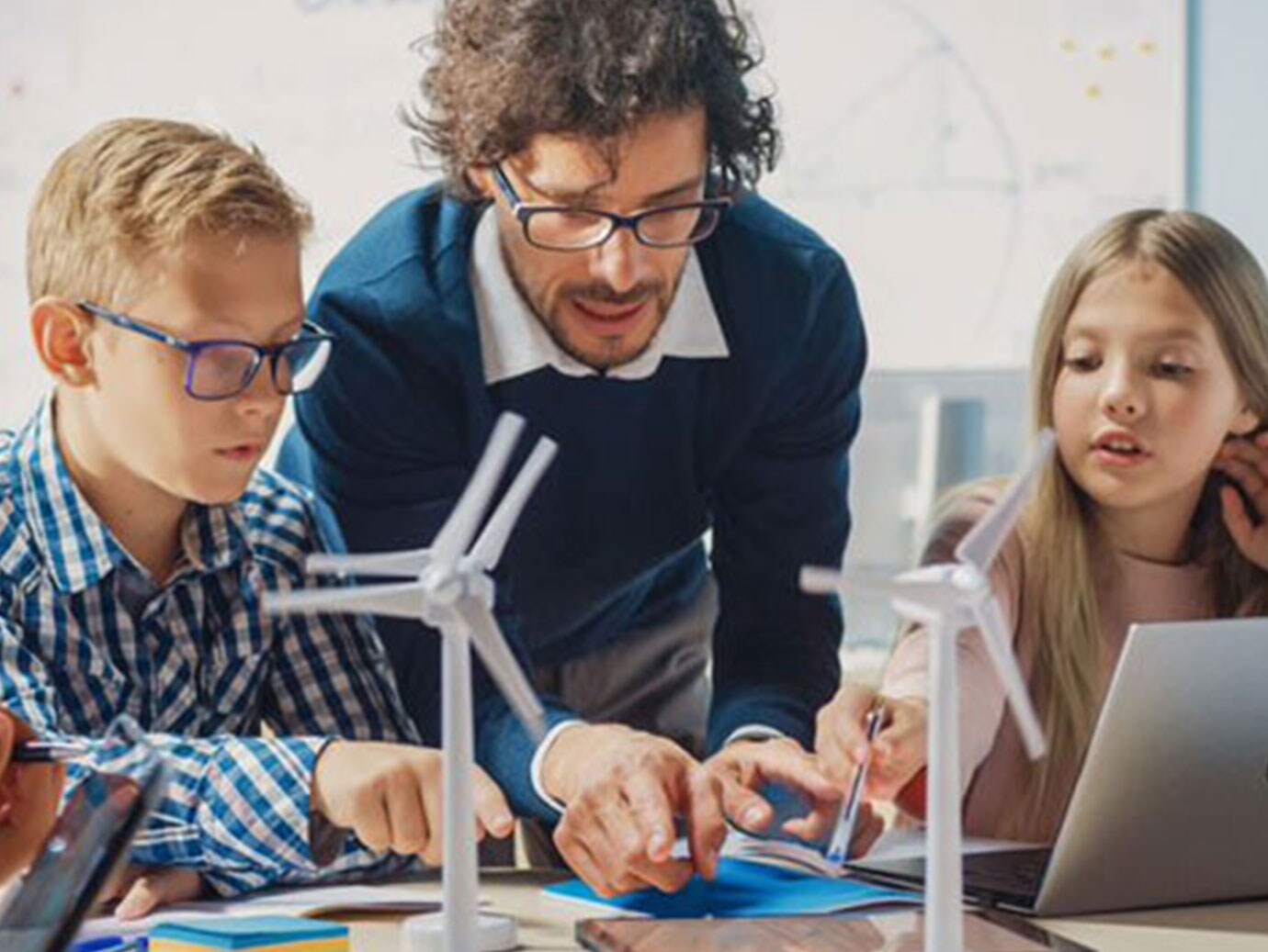 Teacher demonstrating his lessons to the students using models of windmills