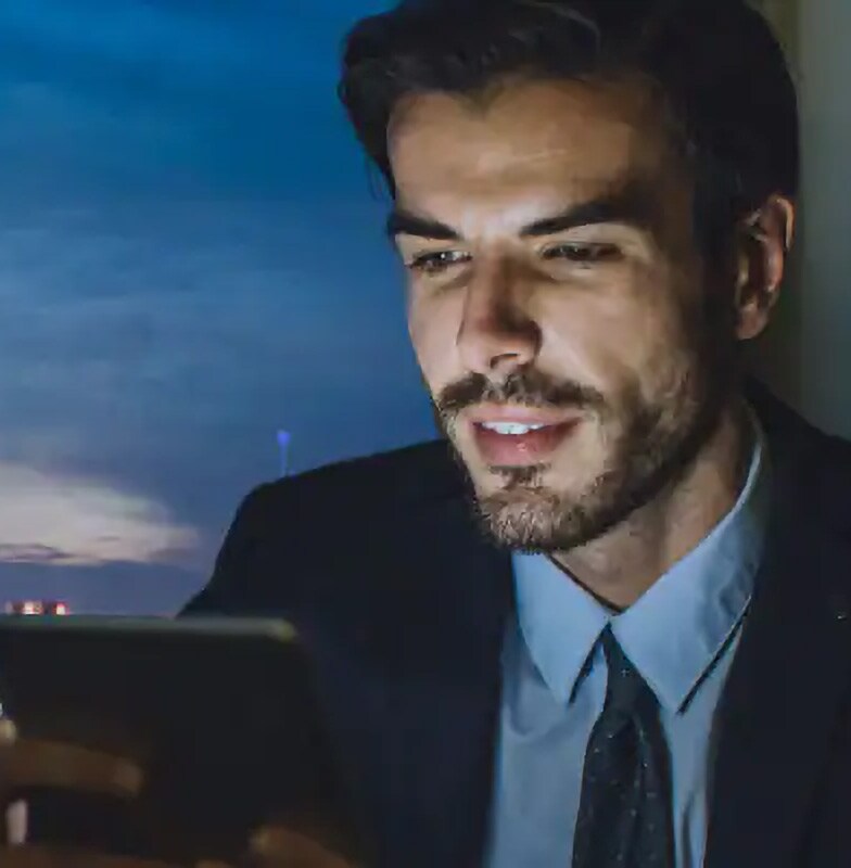 Close-up of a man using a tablet, with the cityscape in the background