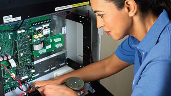 A woman working on a printed circuit board