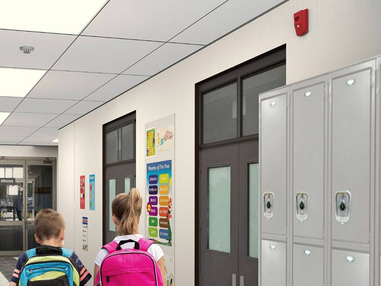 Rear-view image of two children walking in a school corridor