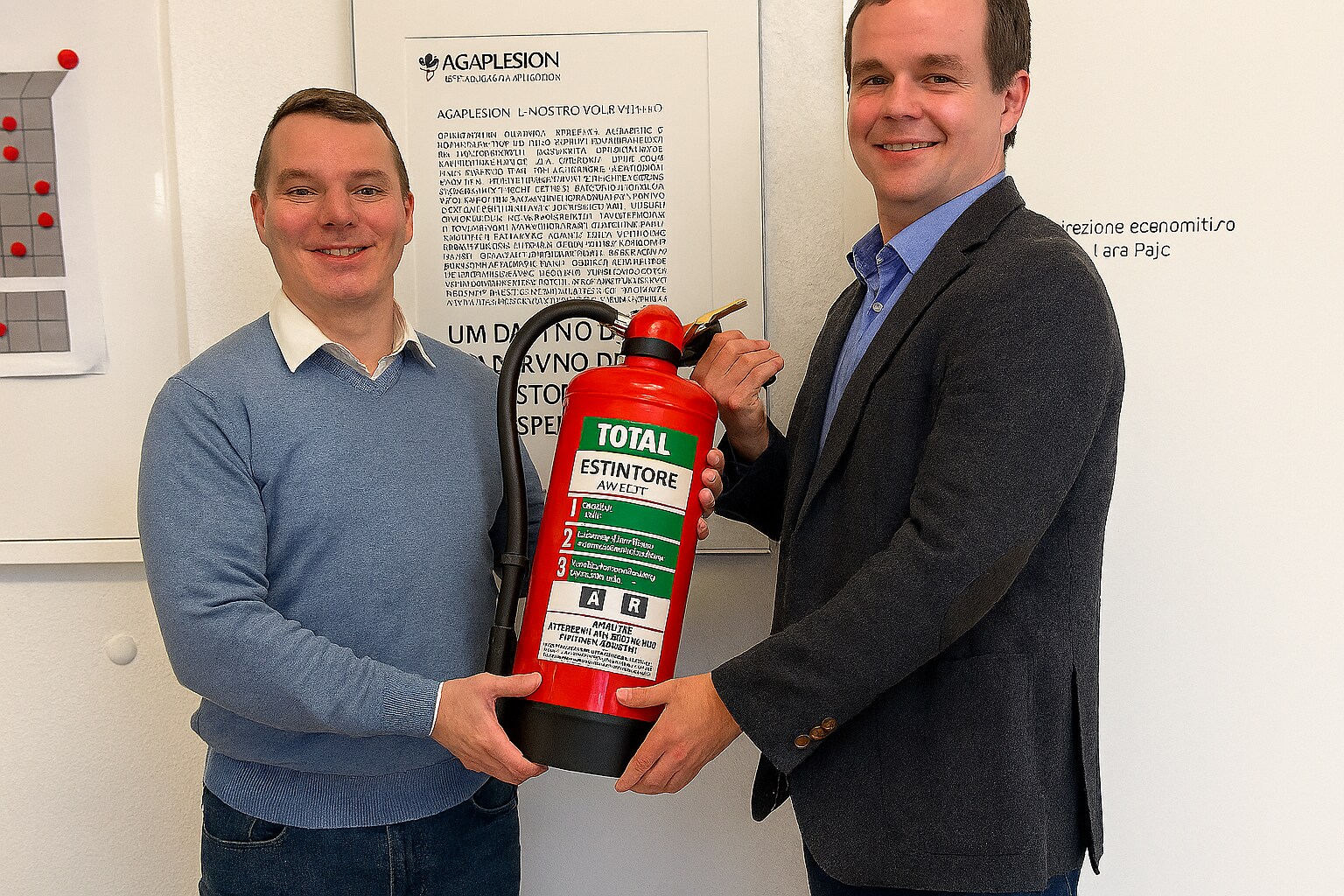 Two people holding a Total fire extinguisher